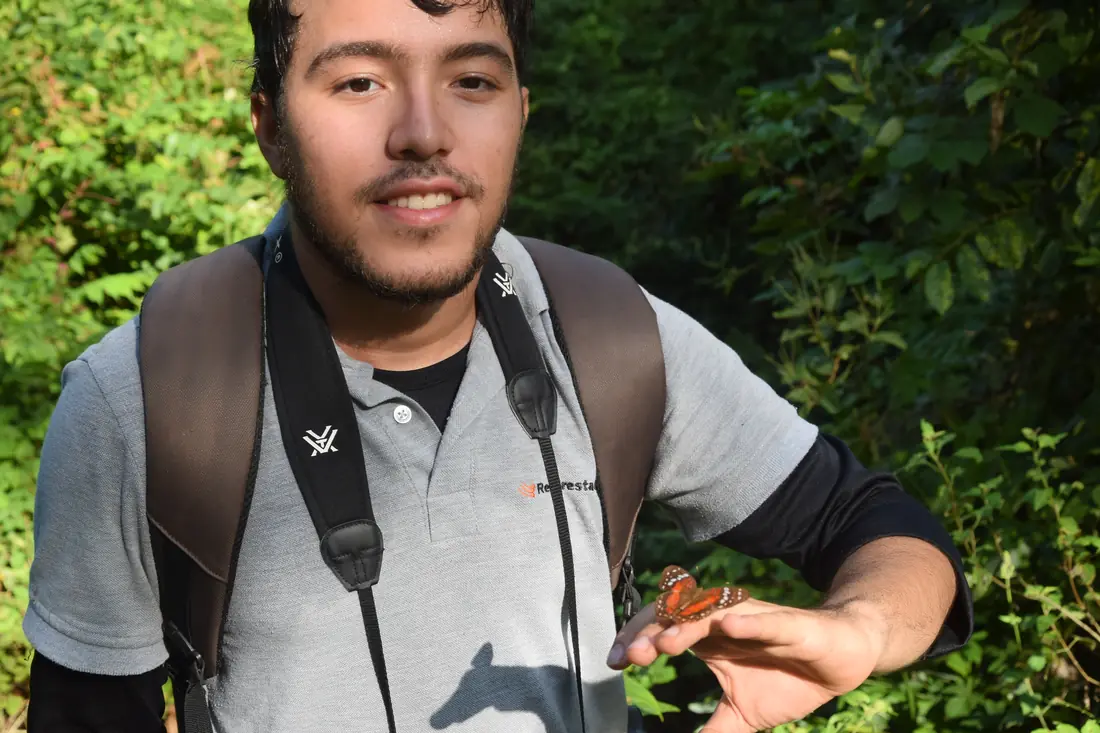 Miguel Ángel Parejo Tovar sostiene una mariposa en una salida de campo