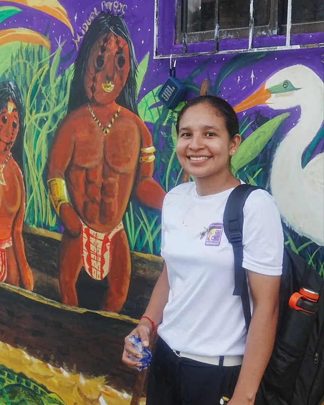 Dianis Edith Pastrana Durango frente a un mural de Bioillustris