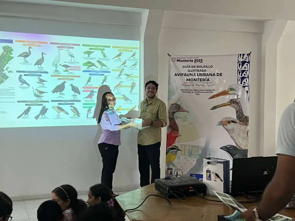 Entrega de la guía de aves en la biblioteca del Colegio Juan Pablo II